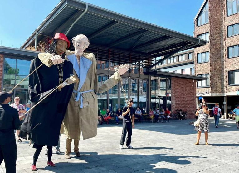 Petra Weller, Auftritt mit Giant Puppets der Gruppe „Fabulanten“ bei der Eröffnung des Kapuzinerplatz in Mönchengladbach als Rapperin Branda.